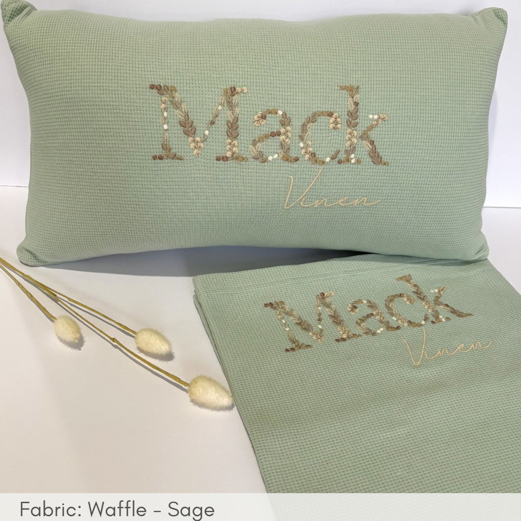 Green pillow and towel set with 'Mack Venue' embroidery on a white background