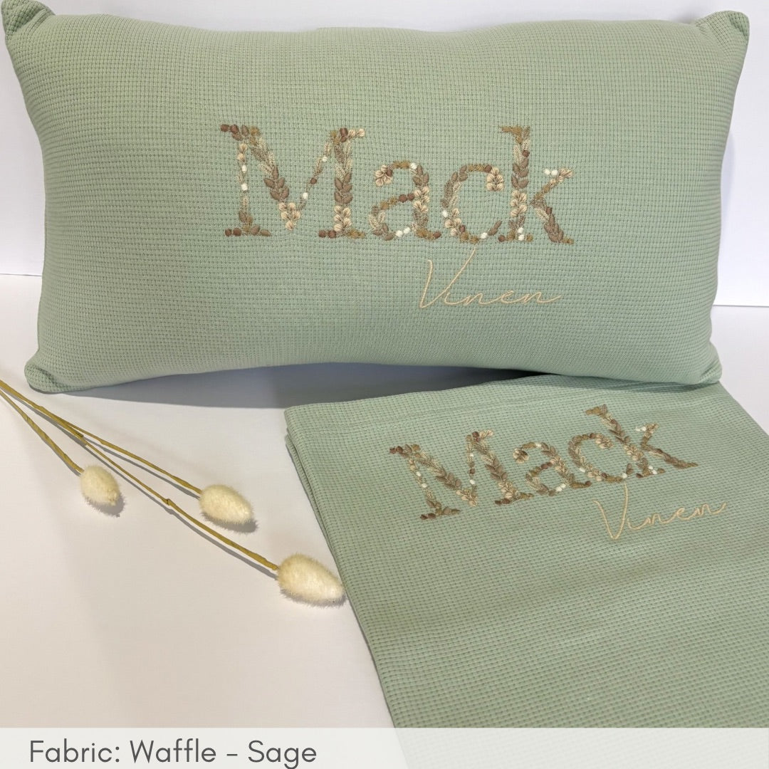 Green pillow and towel set with 'Mack Venue' embroidery on a white background