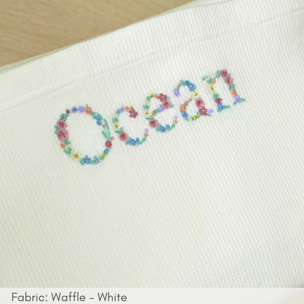 Embroidered name 'Ocean' with floral letters on a white fabric background