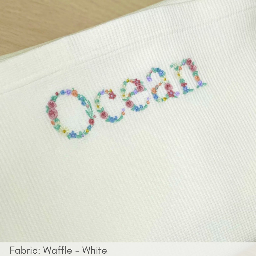 Embroidered name 'Ocean' with floral letters on a white fabric background